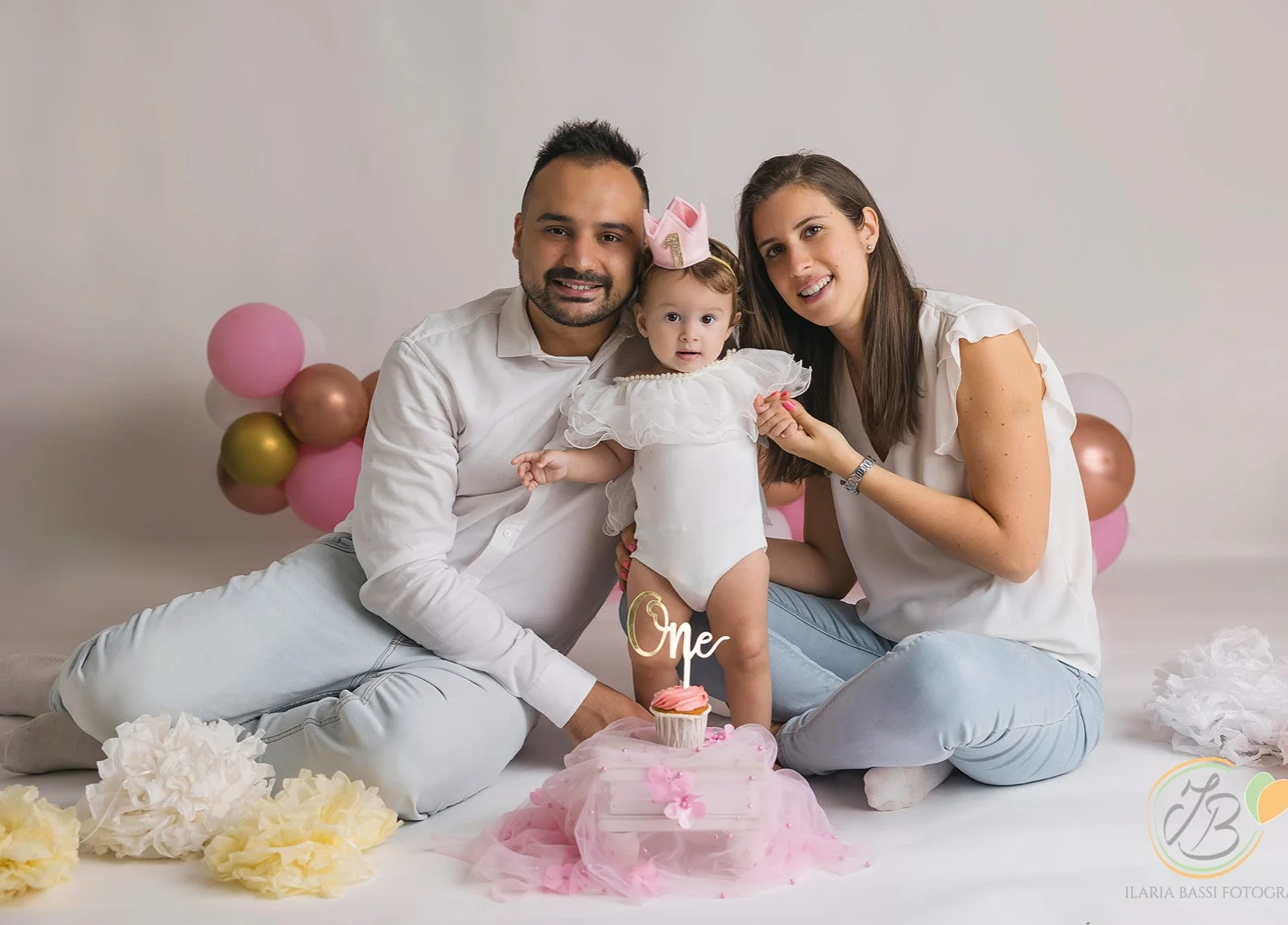 Mamma e papà abbracciano la loro bambina durante il servizio per il primo compleanno