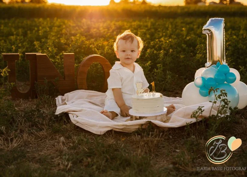Un bambino festeggia il primo compleanno all’aperto nella luce del tramonto