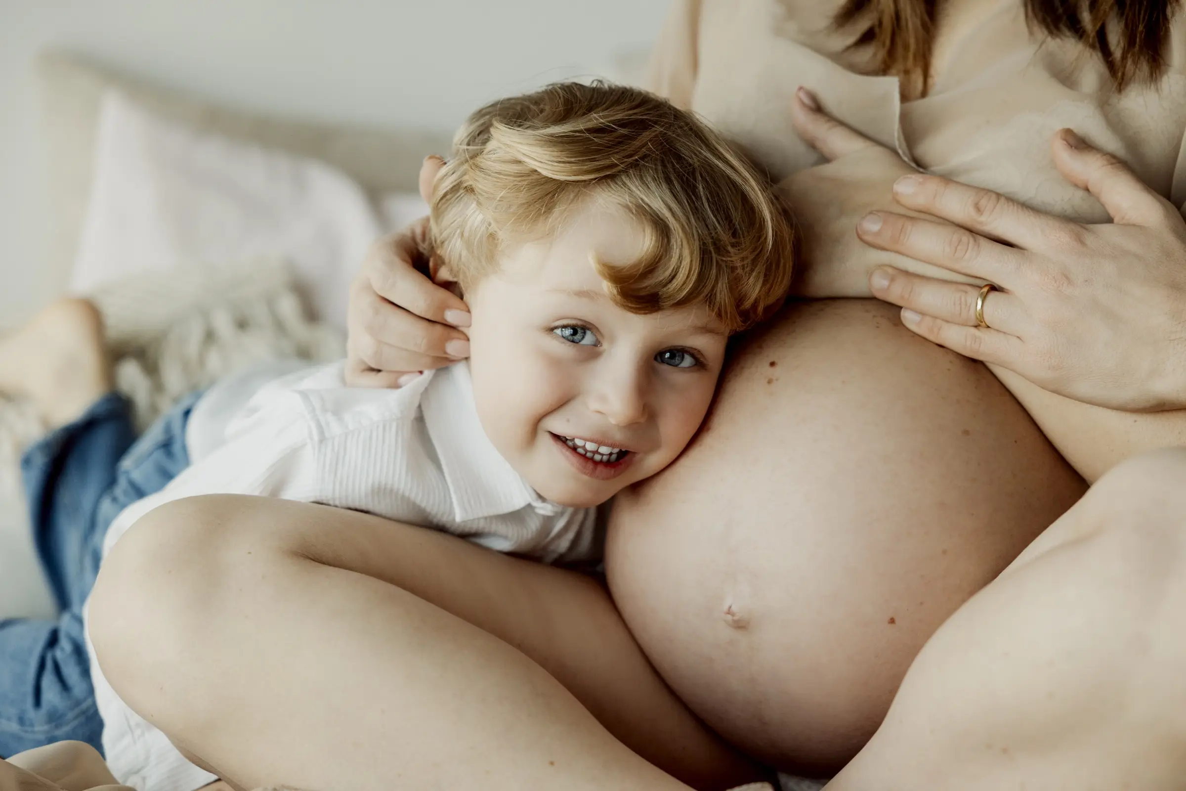 Un bambino abbraccia la mamma in attesa