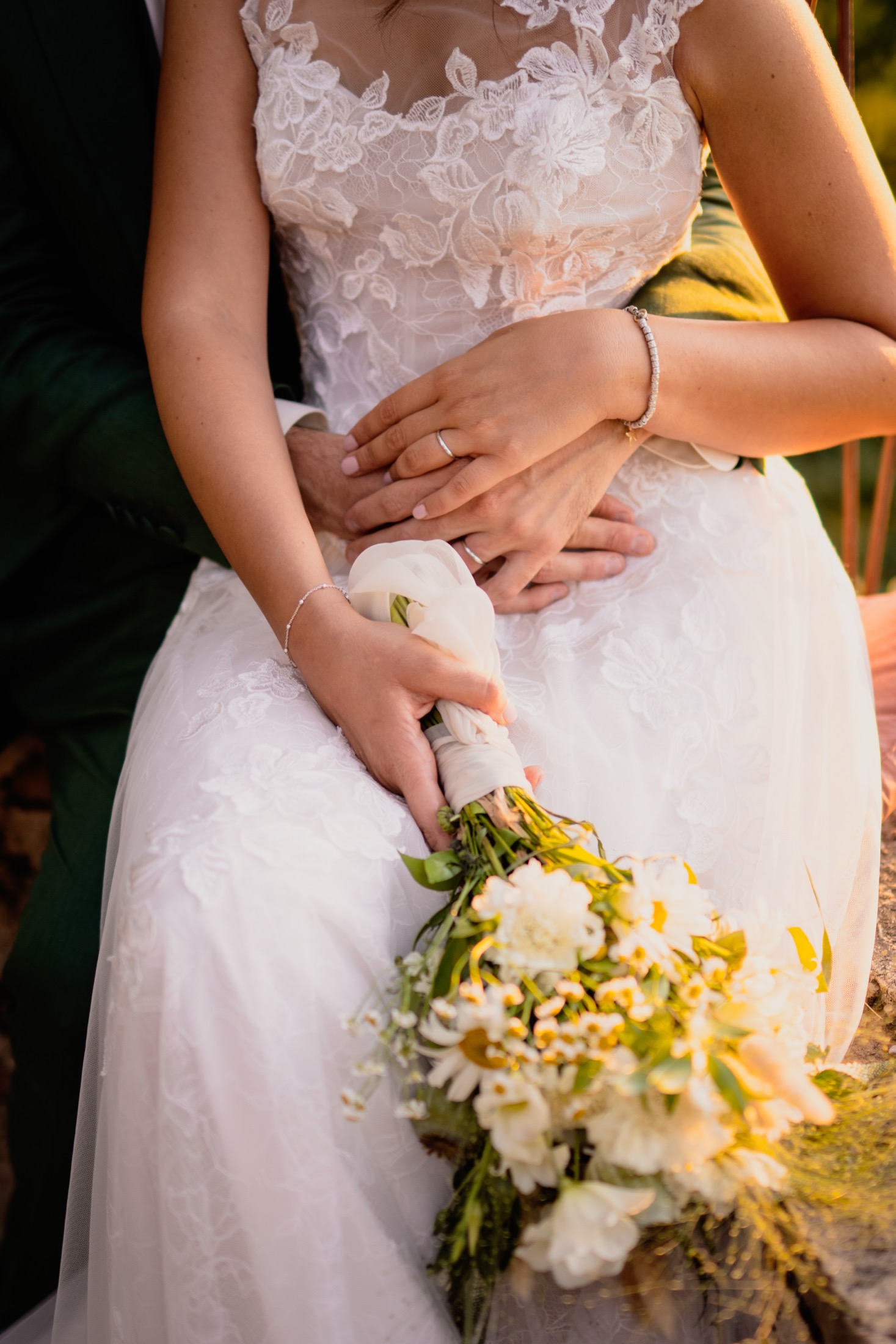 Dettaglio delle mani degli sposi e bouquet